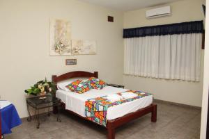 a bedroom with a bed and a table and a window at Grandes Lagos Park Hotel in Jales