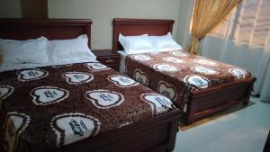 dwa łóżka siedzące obok siebie w sypialni w obiekcie Hotel Dubái w Catamayo