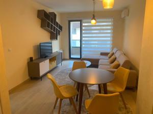 a living room with a couch and a table and chairs at Skopje Eluxory Apartments in Skopje