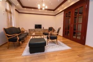 un soggiorno con sedie e TV di Heart of Ferhadija a Sarajevo