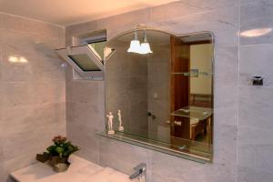 a bathroom with a mirror and a sink at Haris Rooms in Georgioupolis