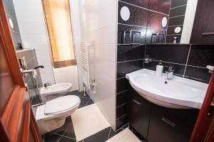 un bagno con un lavandino bianco e un water di Heart of Ferhadija a Sarajevo Altre 22 foto
