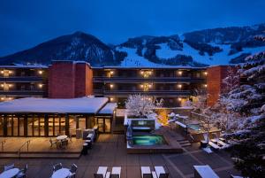 a large building with a snow covered mountain in the background at Aspen Square Condominium Hotel in Aspen