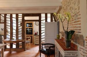 a living room with a table and chairs and a kitchen at Maison D'hôtes Sainte-Marie in Mirande