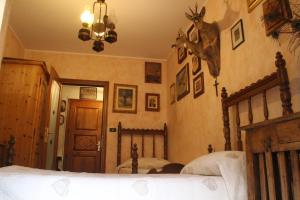Dormitorio con cama con cabeza de ciervo en la pared en Maison du Chasseur, en Charvensod