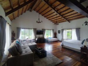 ein großes Wohnzimmer mit einem Bett und einem Sofa in der Unterkunft Hacienda El Pinar del Viento in Villa de Leyva