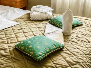 a bed with two pillows on top of it at Hotel Garni Rimski in Novi Sad