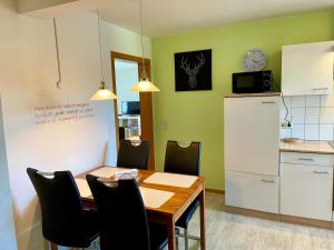 una cucina e una sala da pranzo con tavolo e sedie di Ferienwohnung 'Alte Schmiede' a Teningen Altre 22 foto
