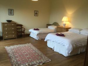 una camera d'albergo con due letti e un tappeto di Lackford Lakes Barns a Flempton