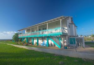 uma grande casa com uma varanda azul e branca em Chalet Olas del Sol em Punta Santiago