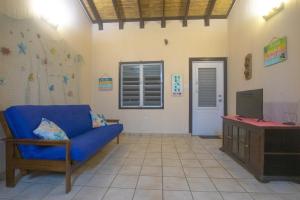 un salon avec un canapé bleu et une télévision dans l'établissement Chalet Olas del Sol, à Punta Santiago