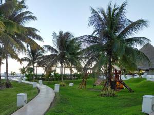 a park with a playground and palm trees at Relaxing beachfront loft in Cancún