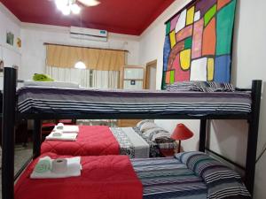 1 dormitorio con 2 literas con sábanas rojas en EnmicasaSSJ-Rosario en Rosario