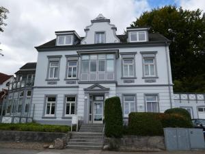 een wit huis met een trap ervoor bij Wohnen am Seglerhafen mit Traveblick im Kontorhaus viele Extras in Lübeck