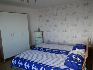 een slaapkamer met een bed met blauwe en witte lakens bij Wohnen am Seglerhafen mit Traveblick im Kontorhaus viele Extras in Lübeck