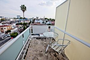 balkon ze stołem i krzesłami oraz miasto w obiekcie Hotel H Americas w mieście Guadalajara