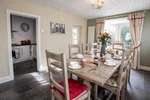 uma sala de jantar com uma mesa de madeira e cadeiras em Newly renovated Old bakery House in Bath, 3 Bedroom, FREE Parking em Bath