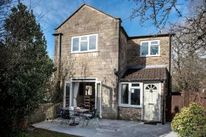 a house with a table and chairs in front of it at Newly renovated Old bakery House in Bath, 3 Bedroom, FREE Parking in Bath