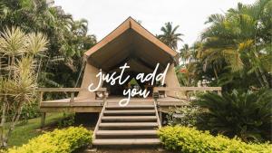 un panneau qui dit juste de vous ajouter sur un bâtiment dans l'établissement Ikurangi Eco Retreat, à Rarotonga