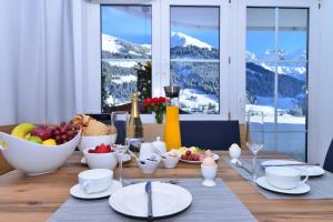 a table with a bowl of fruit and a bowl of food at Villa Vanessa Kleinwalsertal in Mittelberg