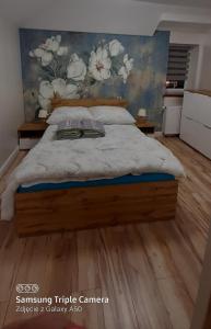 um quarto com uma cama com uma parede floral em Apartamenty U Iwony Centrum miasta blisko Parku Zdrojowego em Kudowa-Zdrój