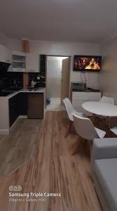 cocina y sala de estar con mesa y sillas en Apartamenty U Iwony Centrum miasta blisko Parku Zdrojowego en Kudowa-Zdrój