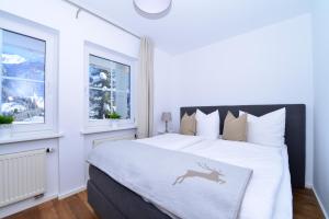 a white bedroom with a bed with a deer stencil on it at Villa Vanessa Kleinwalsertal in Mittelberg