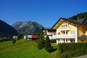 a house on a hill with mountains in the background at Villa Vanessa Kleinwalsertal in Mittelberg