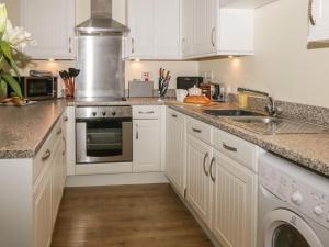 a kitchen with white cabinets and a sink at Cadliam in Whitby