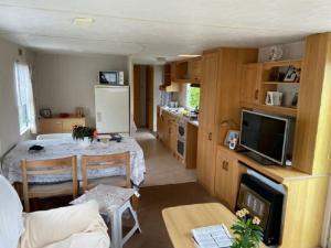 a kitchen and living room with a table and a refrigerator at Inviting Mobile Home in Auw near Lake, City Centre in Auw