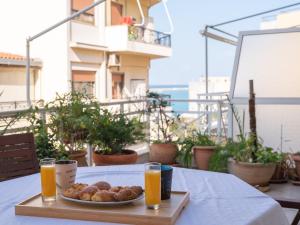 a table with a plate of food and two glasses of orange juice at Luxury Apts Heraklion Center in Heraklio Town