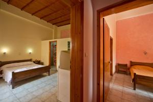 Un dormitorio con una cama y un frigorífico. en Katerina Traditional Rooms, en La Canea