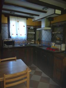 eine Küche mit einem Holztisch und einem Fenster in der Unterkunft Finca Josefina in Miengo
