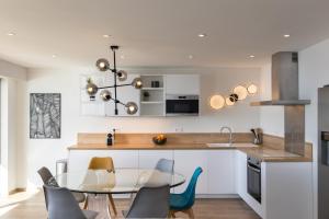 a kitchen with a glass table and chairs at Vue Mer Panoramique, Clim, Balcon et Plages in Antibes