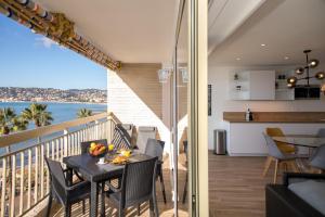 a balcony with a table and chairs and a view of the ocean at Vue Mer Panoramique, Clim, Balcon et Plages in Antibes