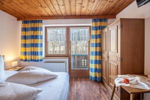 a bedroom with two beds and a window and a table at Ferienwohnung Brugger 6 Personen in Kaltenbach