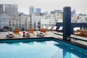 a pool on the roof of a building with chairs at Boutique Apartments - San Telmo in Buenos Aires