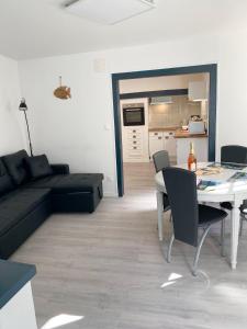 a living room with a black couch and a table at L’Abri Côtier in Le Tréport