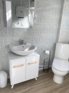 a bathroom with a white sink and a toilet at L’Abri Côtier in Le Tréport