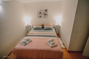 a bed in a room with two towels on it at Green Valley House Madeira in Ribeira Brava