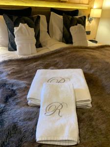 a bed with two towels on top of it at New, Luxurious and Central Art Penthouse in Verbier