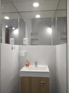 y baño con lavabo y espejo. en La Comarca, en Colonia del Sacramento