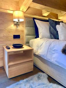 een slaapkamer met een bed en een tafel met een kom erop bij New, Luxurious and Central Art Penthouse in Verbier