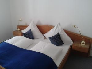 a bedroom with two beds with blue and white pillows at Forst´s Landhaus in Riedenburg