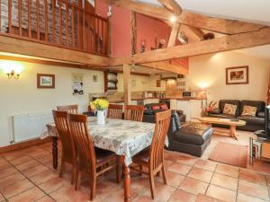 a kitchen and living room with a table and chairs at The Old Stables in Ross on Wye