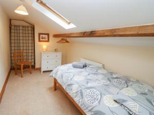 a bedroom with a bed with a blue and white bedspread at The Old Stables in Ross on Wye