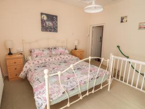 1 dormitorio con cama blanca y almohadas rosas en Northgate Cottage en Holywell