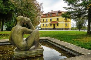 a statue of a woman sitting on a fountain in a park at Apartmány Na Seníku in Třeboň