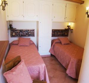 two beds in a room with white cabinets at Villa Raggio Di Sole in Porto Santo Stefano +39 photos
