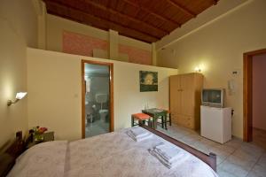 1 dormitorio con cama, TV y baño en Katerina Traditional Rooms, en La Canea